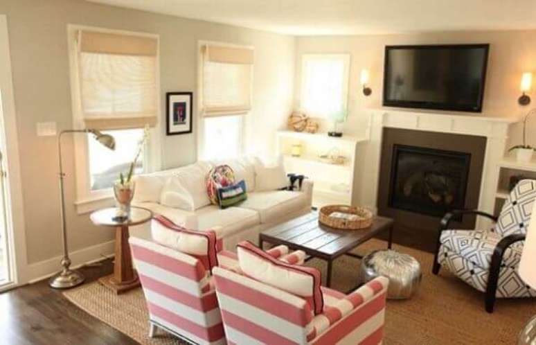 52- A sala de estar com lareira tem a tv fixada no alto. Fonte: Nada Fr&aacute;gil