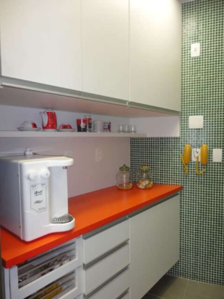 43. Cozinha planejada com armário de cozinha de parede branca e bancada laranja. Projeto de Maria Helena Torres