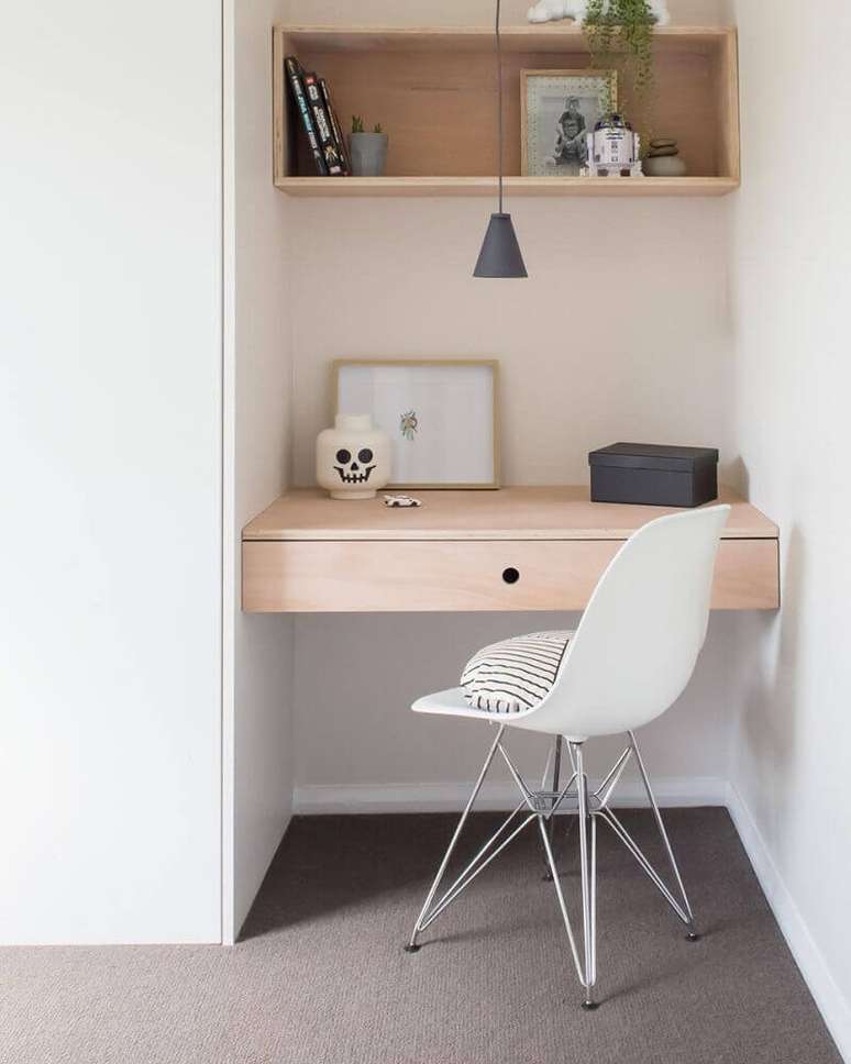 61. Home office pequeno decorado com nicho e bancada de madeira e cadeira de plástico moderna com pés de metal – Foto: Apsip