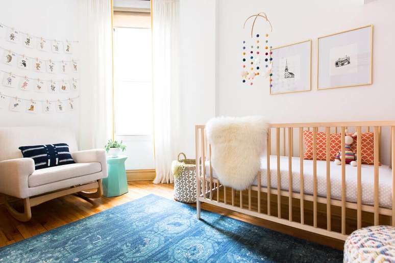 65. Modelo confortável de cadeira de amamentação moderna para quarto de bebê decorado com tapete azul – Foto: Rehabitat Interiors