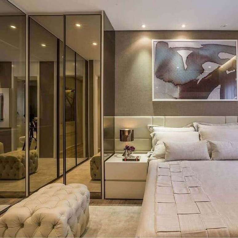 44. Quarto de casal decorado com puff capitonê e guarda roupa espelho bronze – Foto: PinMash