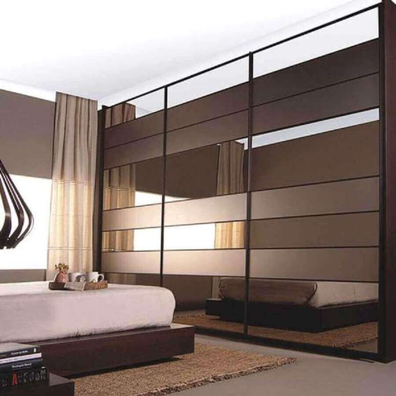 68. Quarto decorado com cama japonesa e guarda roupa espelho bronze – Foto: Habilis