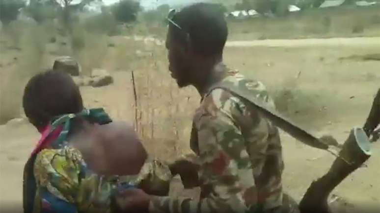 Un soldado empuja a una mujer