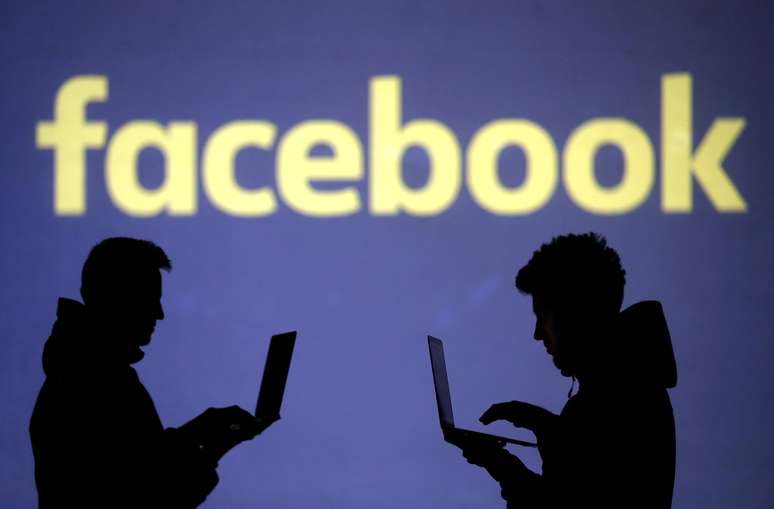 Pessoas usam laptops em frente à logo do Facebook 28/03/2018  REUTERS/Dado Ruvic
