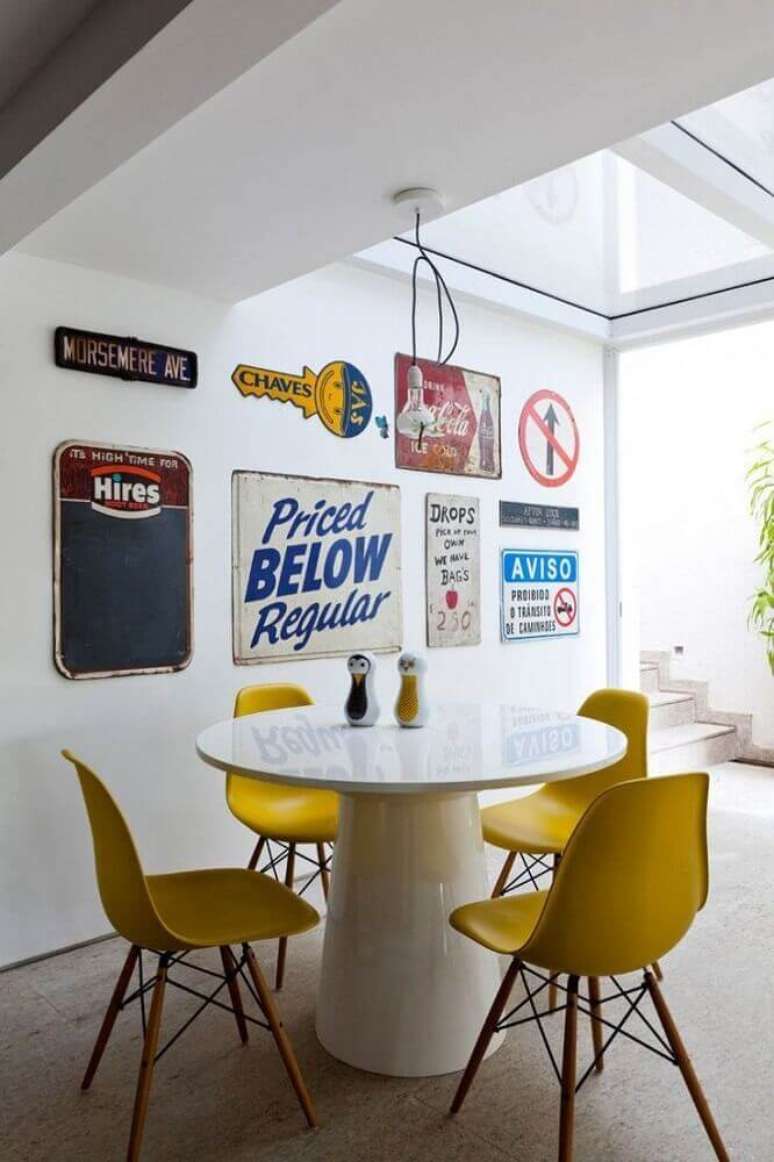 21. Decoração com mesa laqueada branca, cadeiras de plástico modernas e plaquinhas decorativas na parede – Foto: Archilovers
