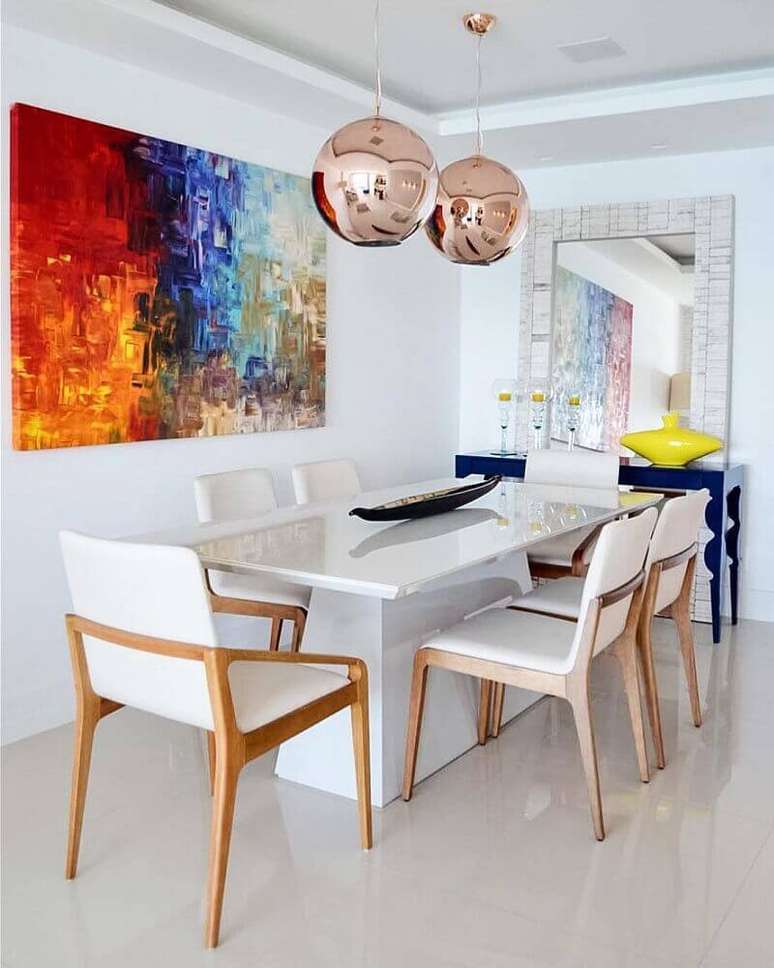 55. Sala de jantar moderna e clean decorada com grande quadro colorido, mesa laqueada branca e pendentes redondos na cor rosé – Foto: Amanda Miranda Arquitetura