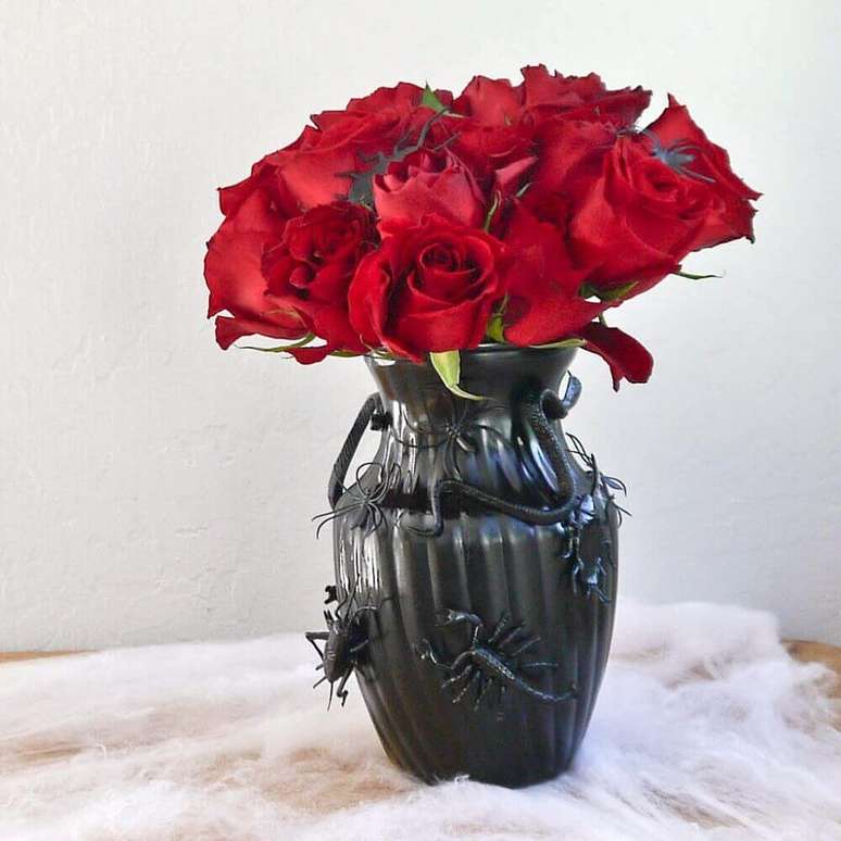 70. Vasos pretos com arranjo de flores vermelhas são perfeitos para decoração de dia das bruxas – Foto: Popsugar