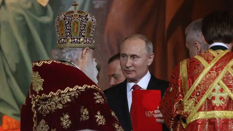 Vladimir Putin durante celebração na catedral ortodoxa de Moscou; presidente russo tenta fortalecer a religião na identidade do país