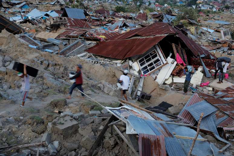 Moradores carregam pertences após terremoto atingir o distrito de Palu, na Indonésia 01/10/2018 REUTERS/Beawiharta