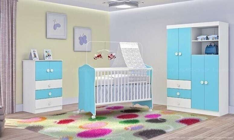 51- No quarto de bebê menino as portas dos móveis são azuis e o tapete tem estampa com círculos coloridos grandes. Fonte: LojasKD
