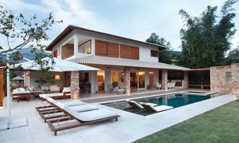 44. Varanda com piscina pequena com espreguiçadeiras dentro. Projeto de Paola Ribeiro