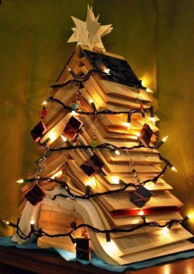 13. Árvore de natal artesanal feita com livros e luzes pisca-pisca