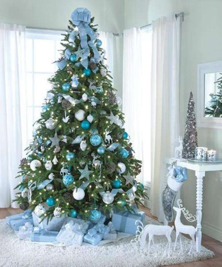 65. Árvore de natal com decoração azul, cheia de bolinhas, renas, estrelas e fitas