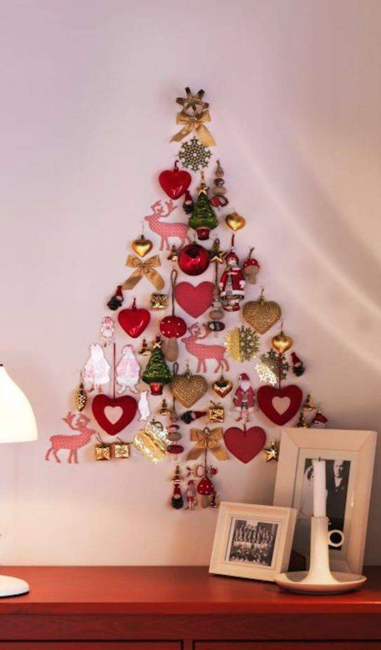 23. Árvore natalina feita na parede com adesivos e enfeites de natal