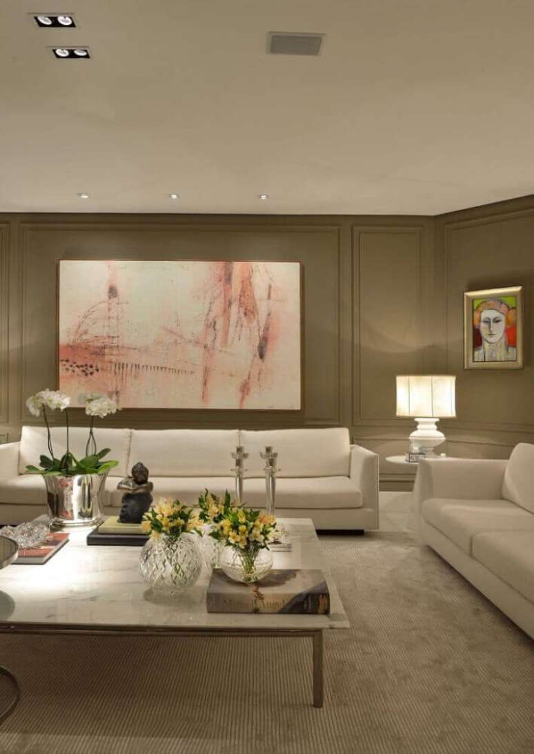27. Decoração clássica em tons neutros para sala com sofá branco e moldura de parede – Foto: Marlon Gama