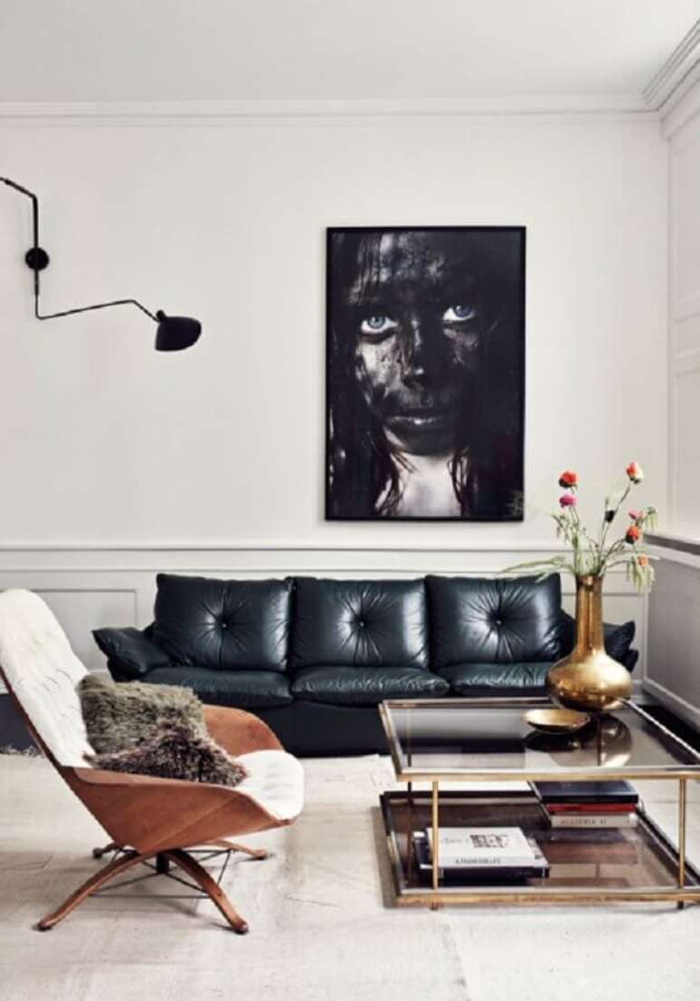 63. Sala moderna decorada com boiserie grande e quadro sobre o sofá de couro preto – Foto: Main Life Style
