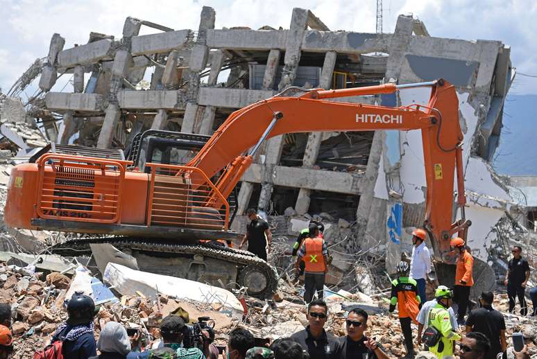 Escavadeira auxilia equipes na busca por corpos e sobreviventes do terremoto em Palu