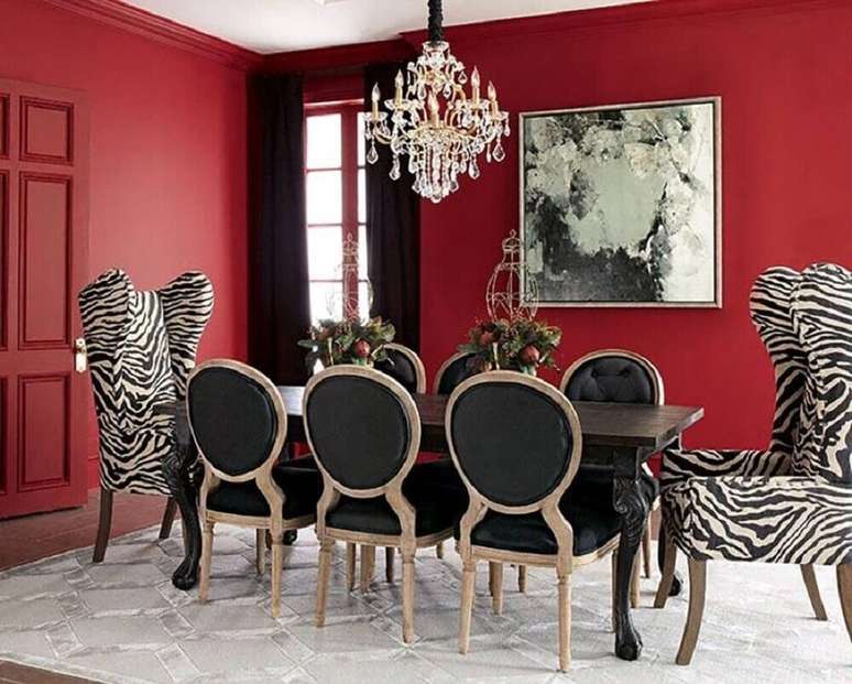 6. Decoração para sala de jantar com paredes vermelhas e mesa petra com poltronas com tecido de zebra – Foto: Pinterest