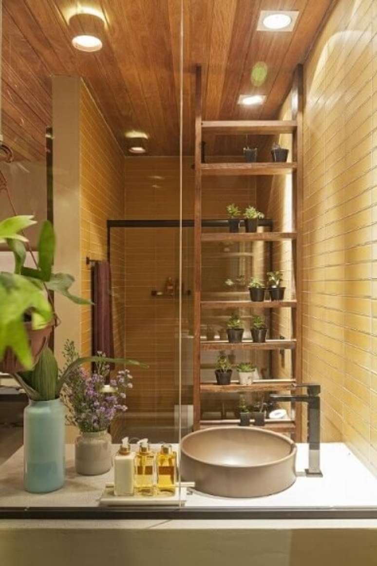 37. Banheiro com plantas em estante vazada de madeira. Projeto de Isabela Bethonico