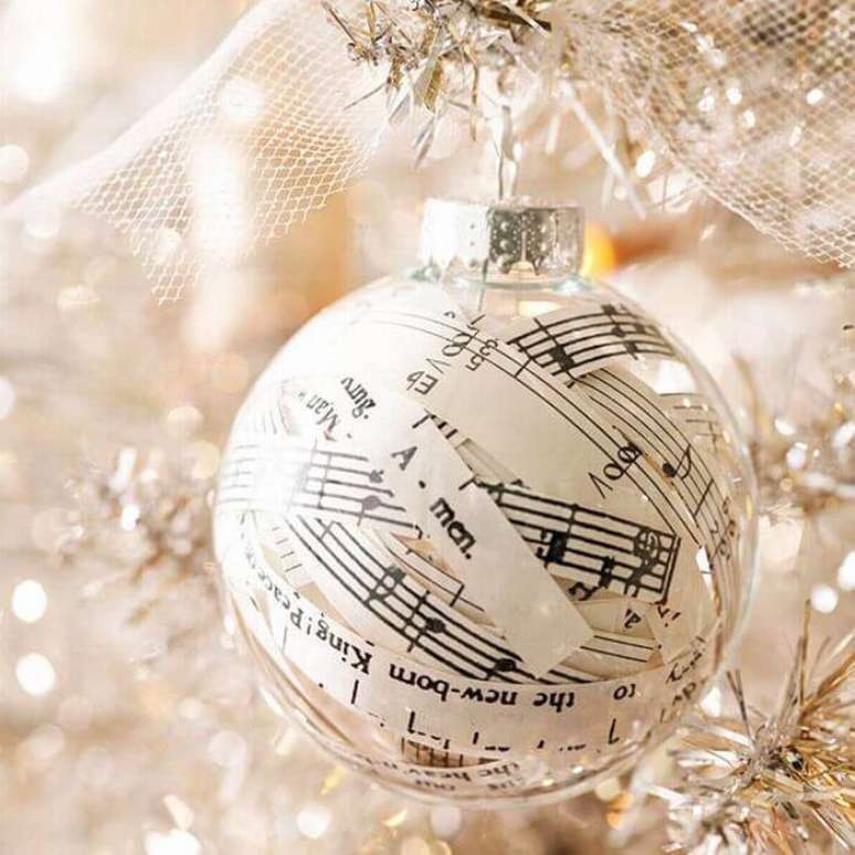 17. Bolinha de natal transparente decorada com partituras de música