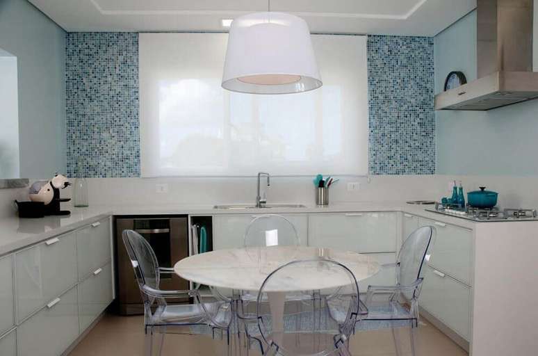49. Decoração clean com armário de cozinha planejado branco e cadeiras de acrílico transparente – Foto: Juliana Pippi