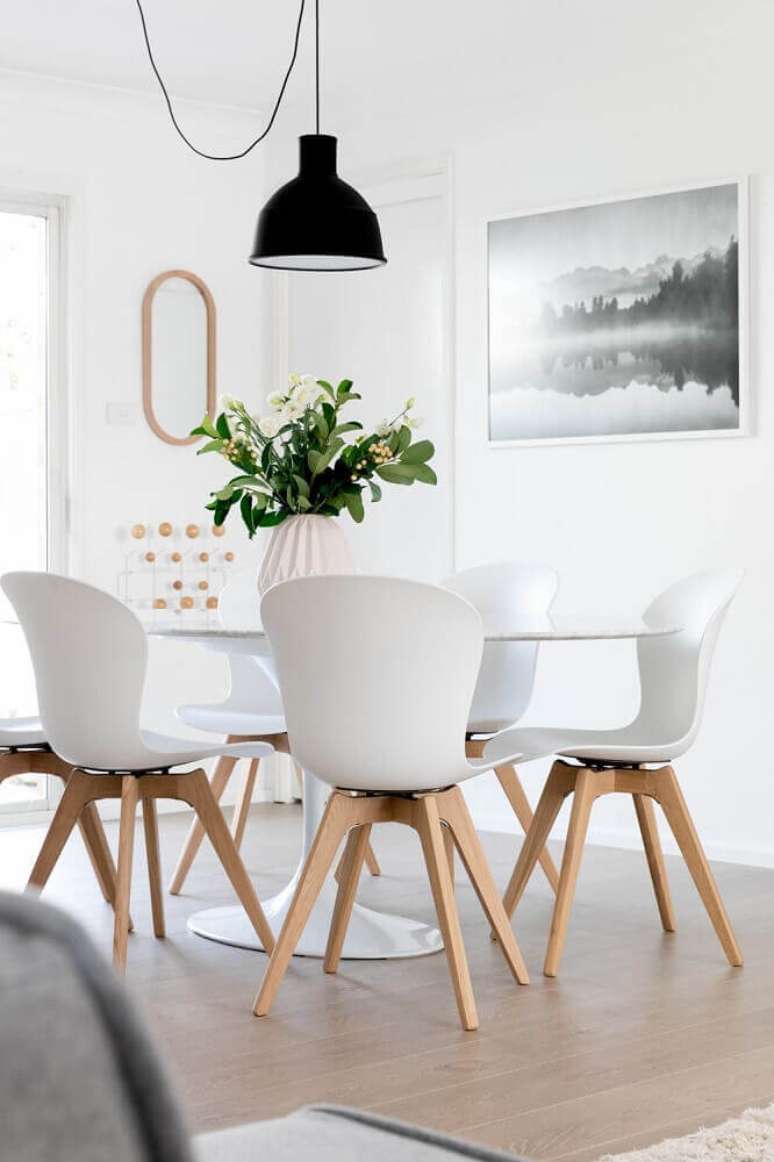 13. Decora&ccedil;&atilde;o clean com cadeiras para sala de jantar moderna e pendente preto sobre a mesa &ndash; Foto: Pinterest