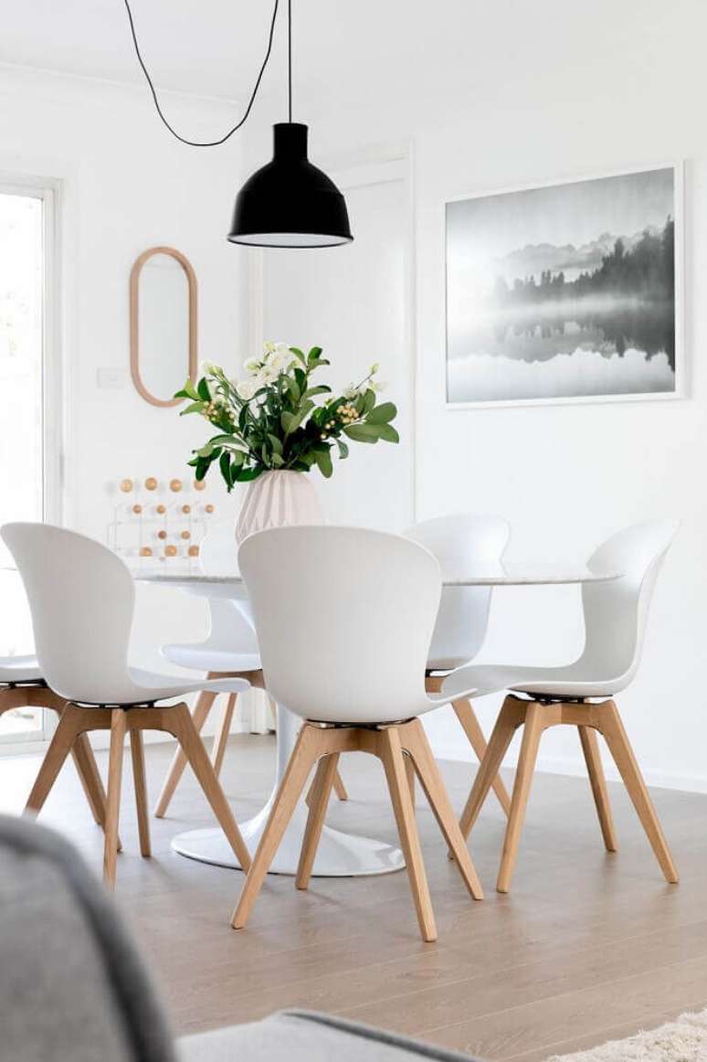 13. Decoração clean com cadeiras para sala de jantar moderna e pendente preto sobre a mesa – Foto: Pinterest