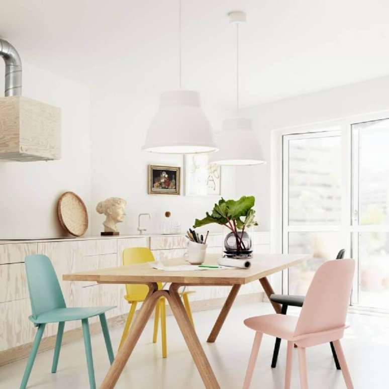 17. Decora&ccedil;&atilde;o clean para sala de jantar com cadeiras coloridas em tom pastel e pendentes brancos sobre a mesa de madeira &ndash; Foto: Nicholas C Johnson