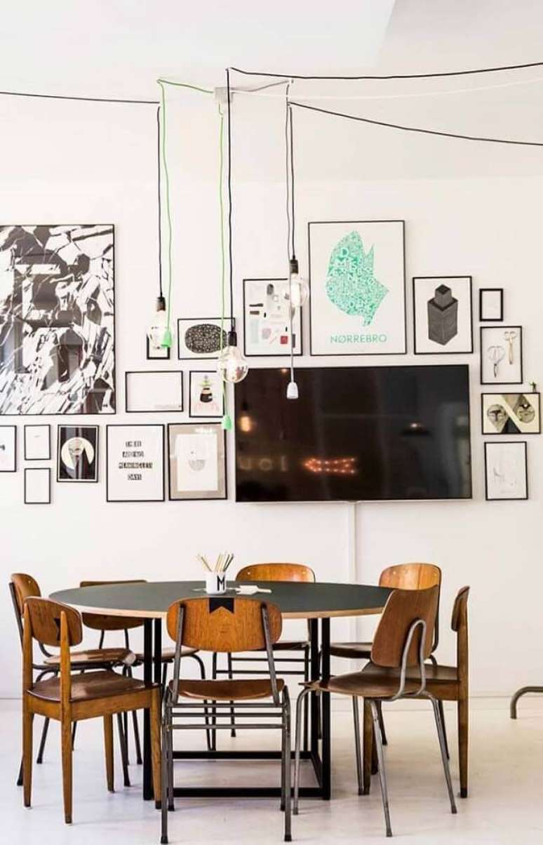 9. Decoração de sala de jantar moderna com pendentes minimalistas e muitos quadros na parede – Foto: The Holk