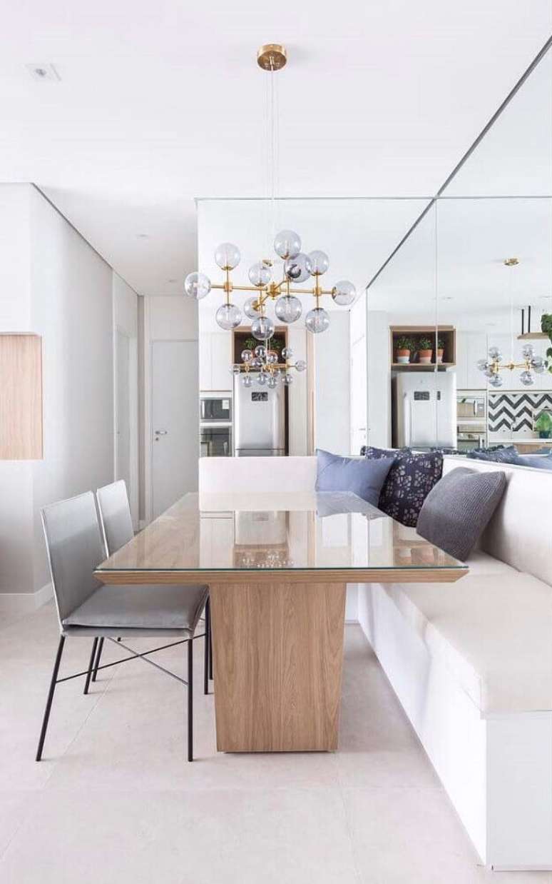 29. Decoração de sala de jantar moderna com canto alemão, pendente minimalista e parede espelhada – Foto: The Holk