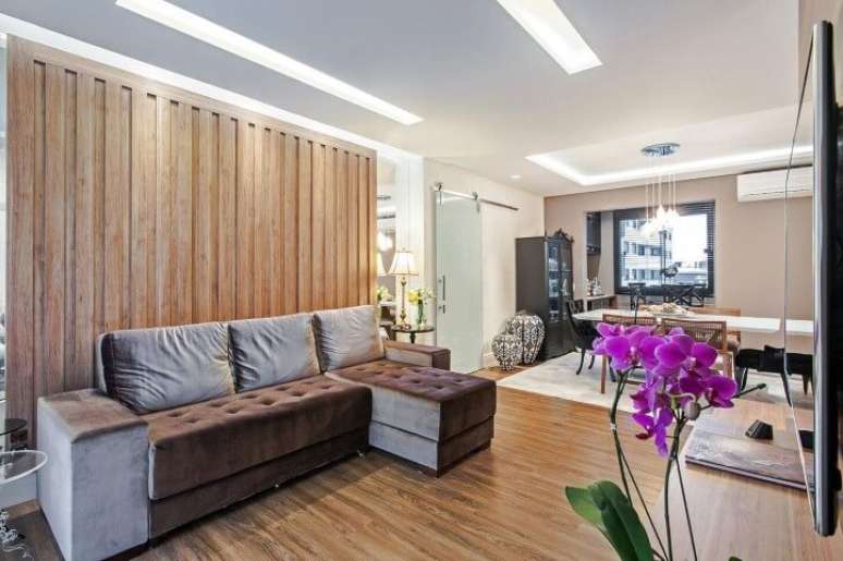 48. O com sof&aacute; com chaise tamb&eacute;m pode ser usado para dividir espa&ccedil;os em ambientes amplos. Projeto de Patricia Azoni