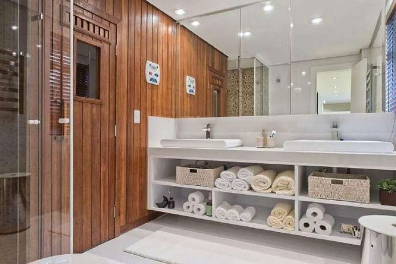 23. Banheiro planejado com nichos embaixo da bancada e grande espelho &ndash; Foto: Samara Barbosa