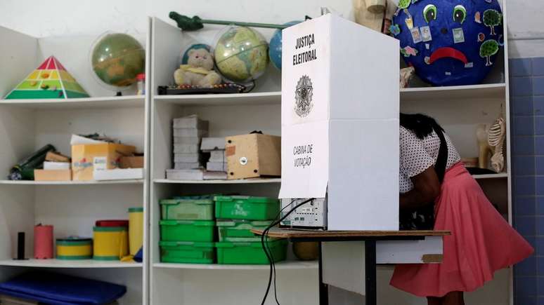 Mulher vota em cabine de votação no primeiro turno das eleições 2018