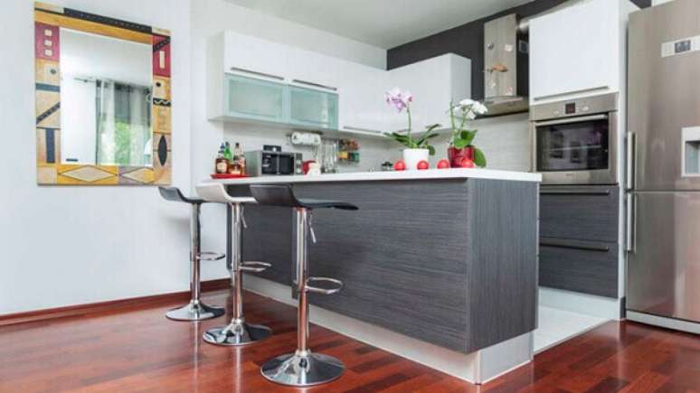 66- A cozinha americana simples foi decorada com revestimento de madeira na cor cinza nas portas dos armários e bancada. Fonte: Idea Brasil