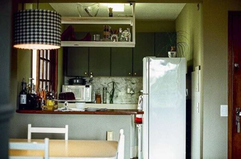 25- Na cozinha americana pequena foi construída uma mureta com tampo em madeira natural. Fonte: Casa Aberta