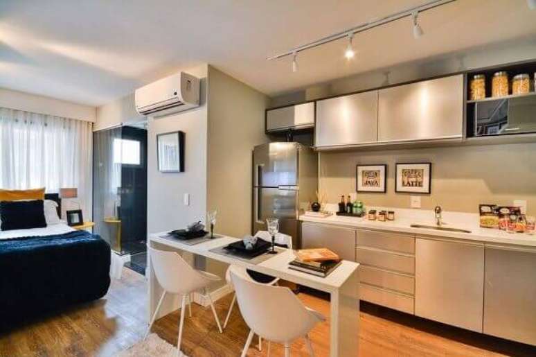 27- No apartamento tipo Studio a cozinha americana pequena ocupa uma parede sem divisórias. Fonte: Bender Arquitetura