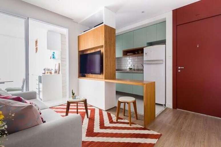 68- A divisória com tv divide a área da cozinha americana pequena com sala simples. Fonte: Pinterest