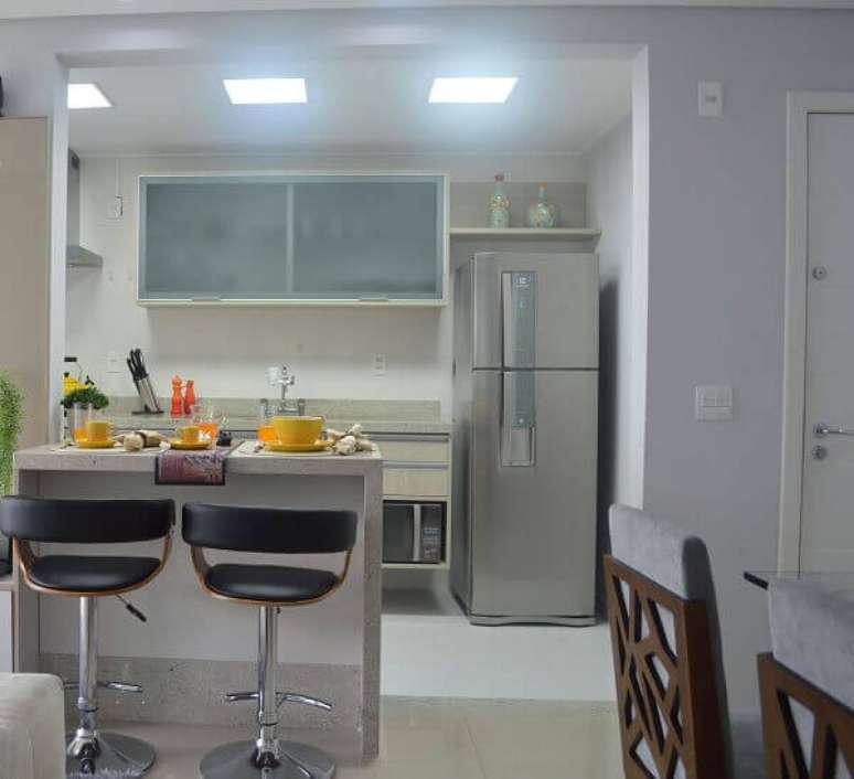 4- Na cozinha americana pequena com sala foram colocados armários suspensos para facilitar a organização do ambiente. Fonte: Pinterest