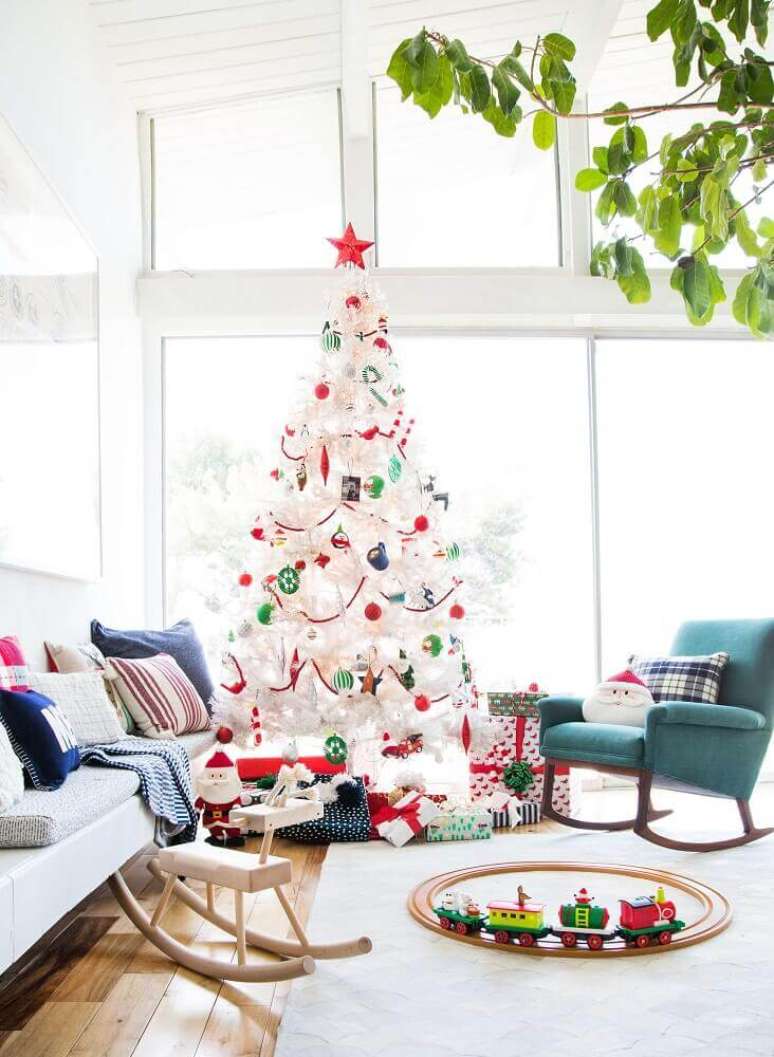 55. Linda decoração para sala bem clara com grande árvore de natal decorada com enfeites coloridos – Foto: Emily Henderson