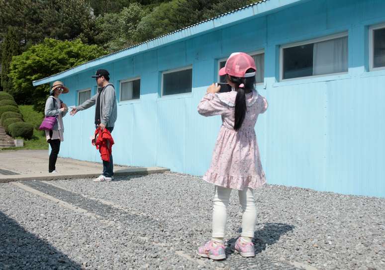 Menina tira foto dos pais no vilarejo de fronteira entre as Coreias de Panmunjom