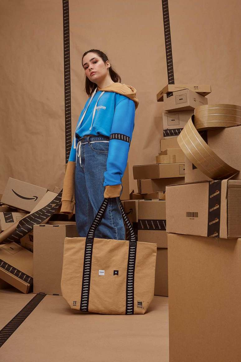 O moletom da cole&ccedil;&atilde;o e a bolsa, com elementos como a fita adesiva da marca e a um bege cor de papel craft