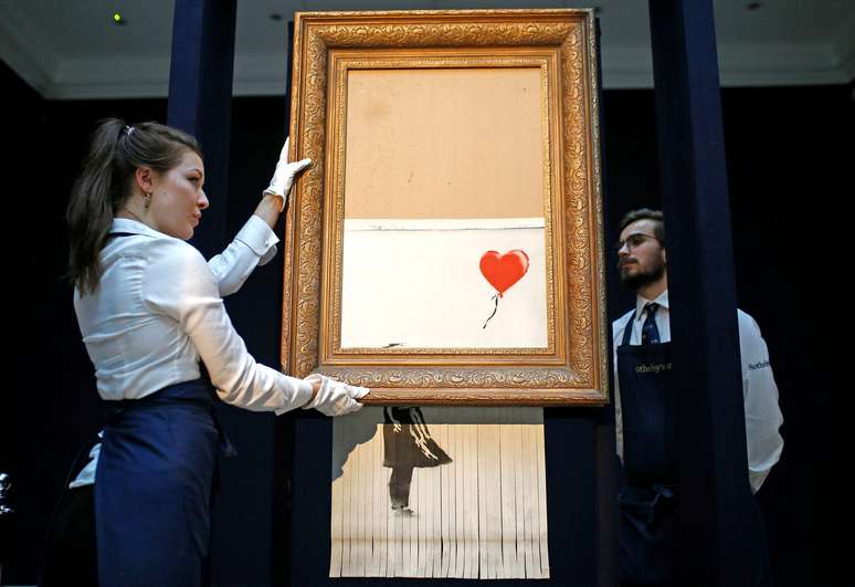 Funcion&aacute;rios reposicionam obra parcialmente destru&iacute;da de Banksy 