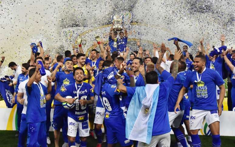 Ao fundo, Henrique levanta a taça da Copa do Brasil e comemora o título (Foto: Eduardo Carmim/Photo Premium)