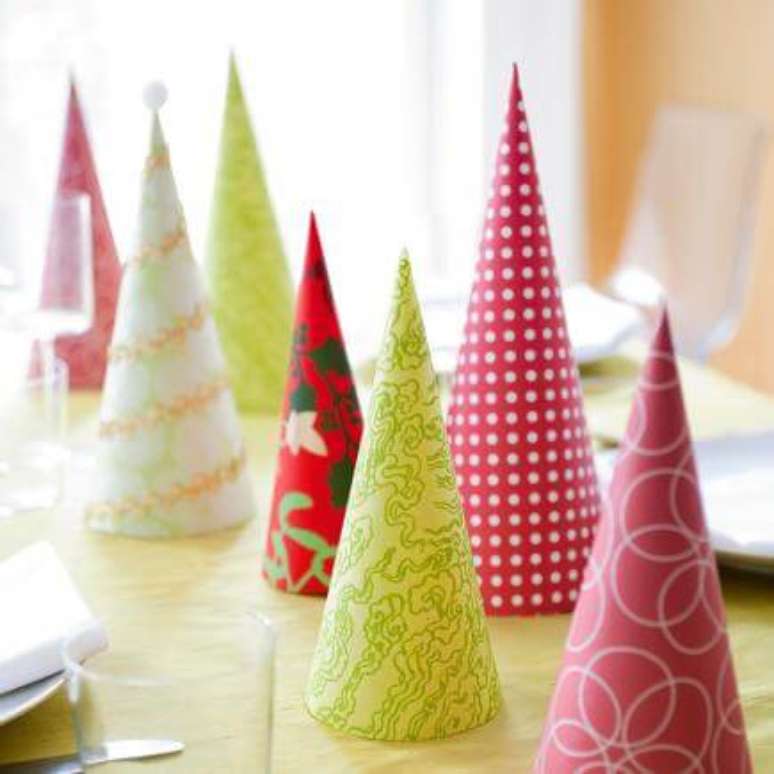 64. Outra opção de DIY é fazer cones de papel coloridos para fazer a decoração de mesa de ceia de natal. Foto de Midwest Living