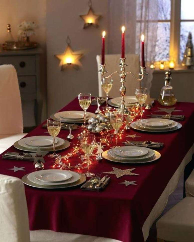66. Toalha de mesa vinho com candelabro dourado e pisca pisca sobre a mesa da ceia de natal. Foto de North Mallow