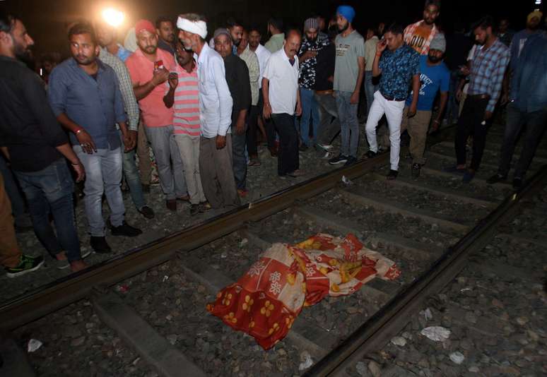 Pessoas cercam corpo de v&iacute;tima de acidente com trem em Amritsar
 19/10/2018    REUTERS/Munish Sharma