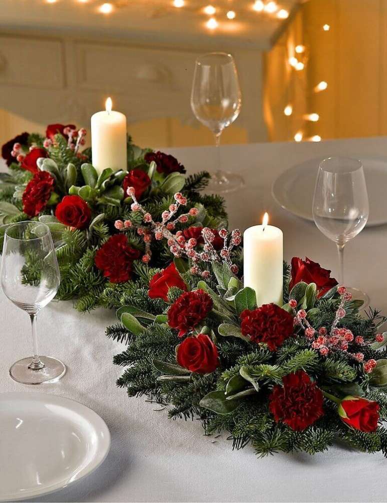 5. Decoração clássica com arranjos de mesa de natal com velas e flores vermelhas – Foto: Marks & Spencer