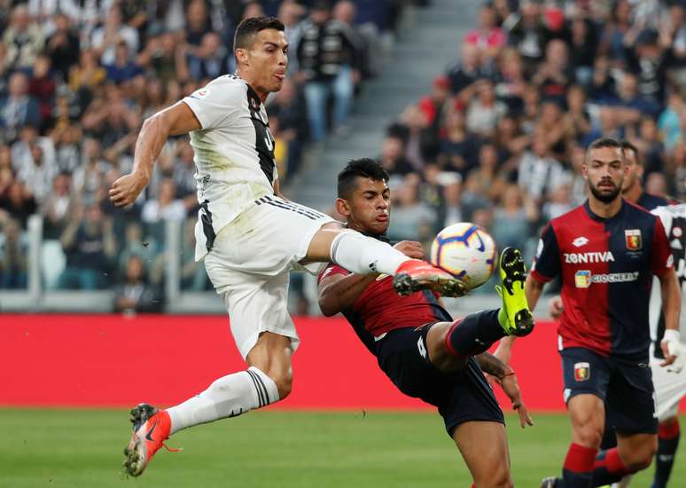 Cristiano Ronaldo tenta o chute em disputa de bola com marcadores do Genoa