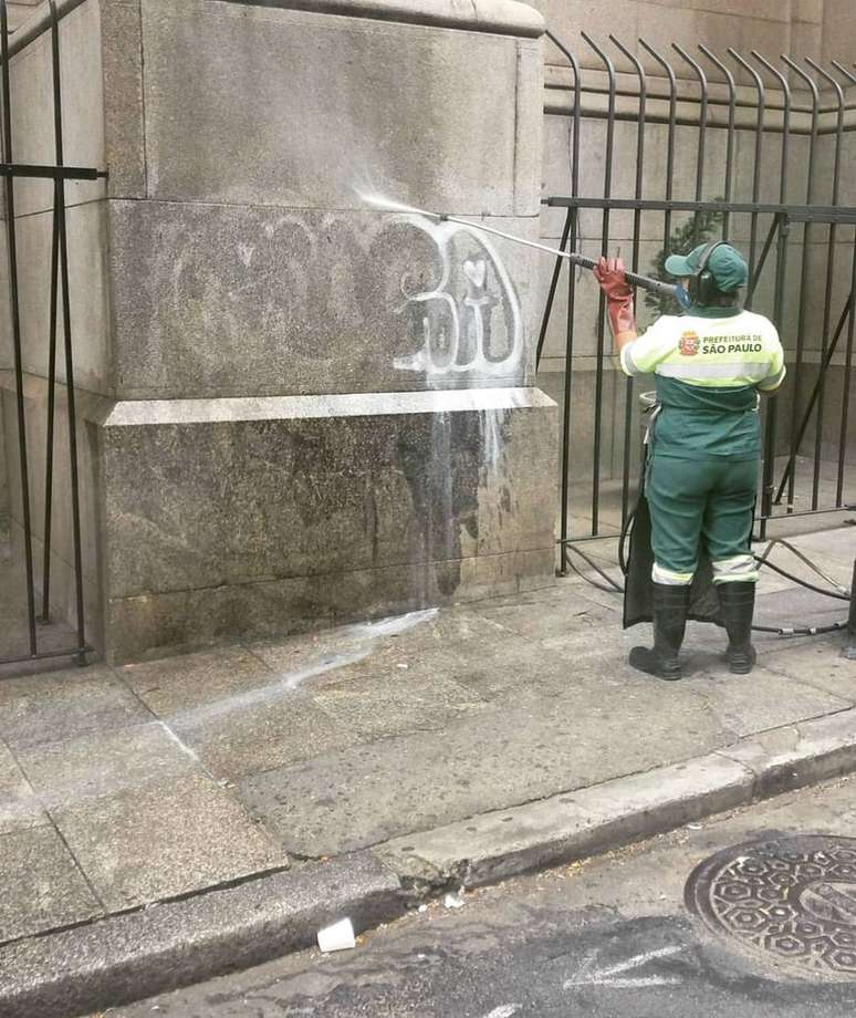 Funcionária da Prefeitura de São Paulo limpa pichação em parede da Catedral da Sé