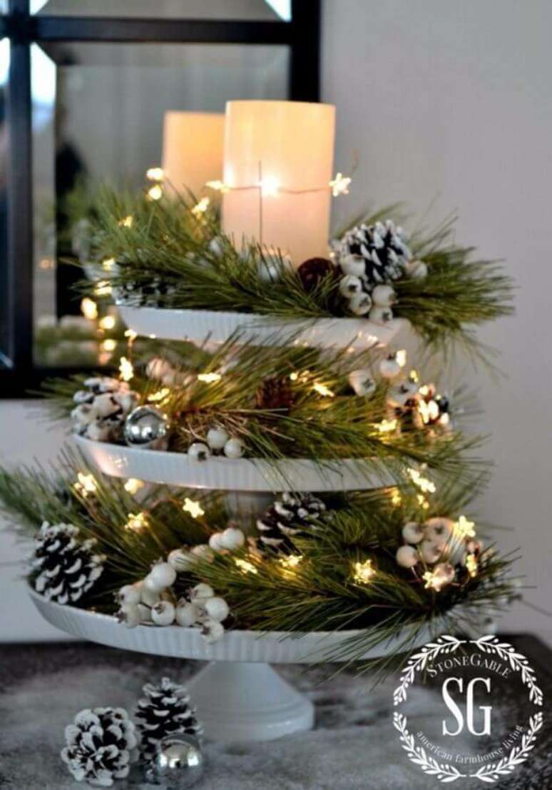 11. Lindo arranjo natalino decorado com pinhas, ramos de plantas e luzes de natal – Foto: HomeDecorish